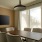 a room with a table and many chairs with a tv one the wall