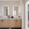 bathroom with dual sinks and backlit mirrors