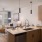 kitchen looking out into living room with ample lighting 