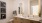 bathroom with dual sinks and backlit mirrors