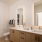 bathroom with dual sinks and backlit mirrors