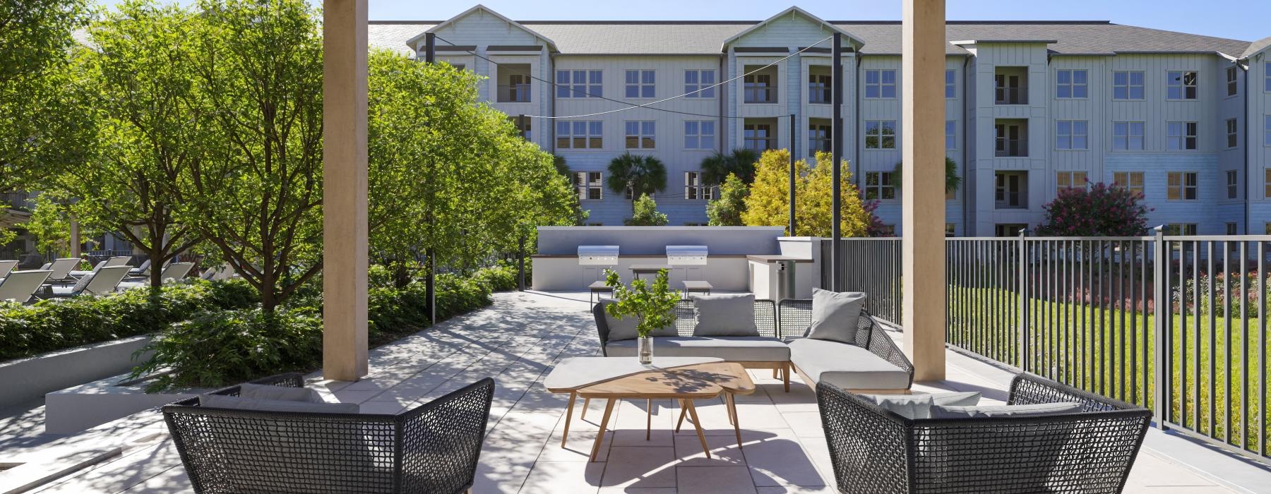 a patio with chairs and tables and a building in the background