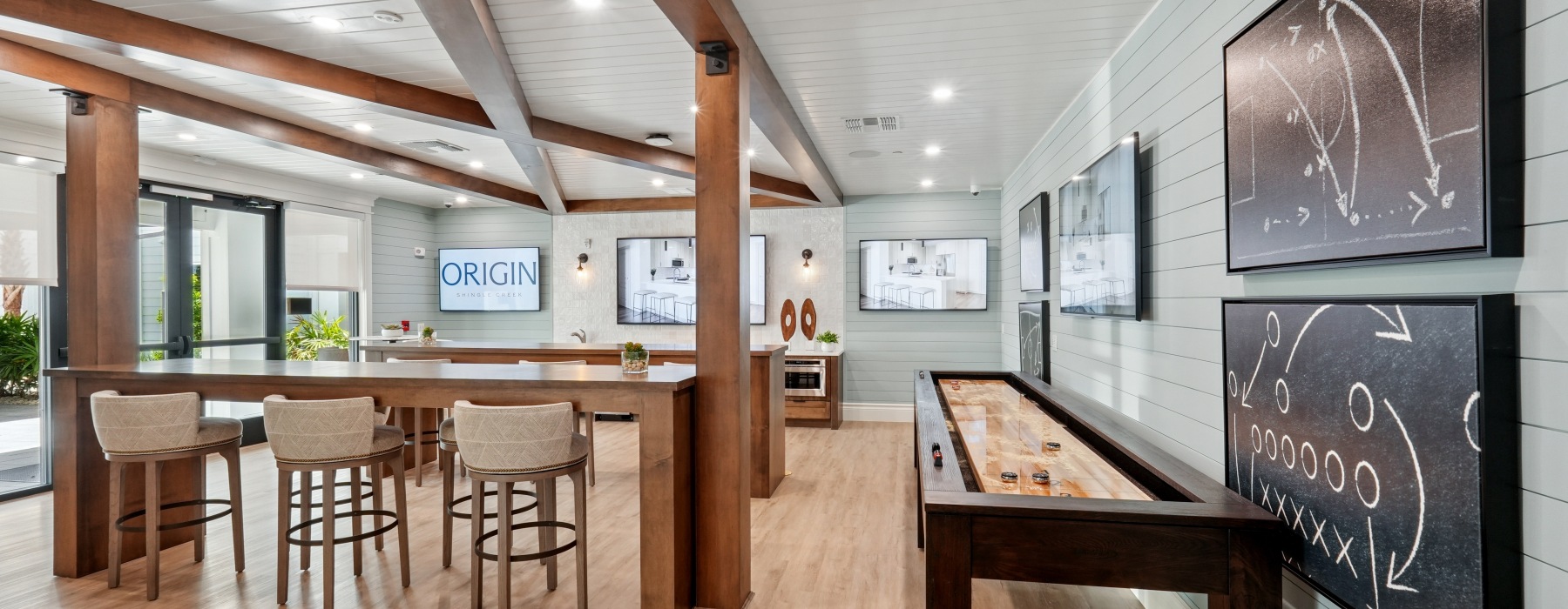 large social room with tvs and game areas