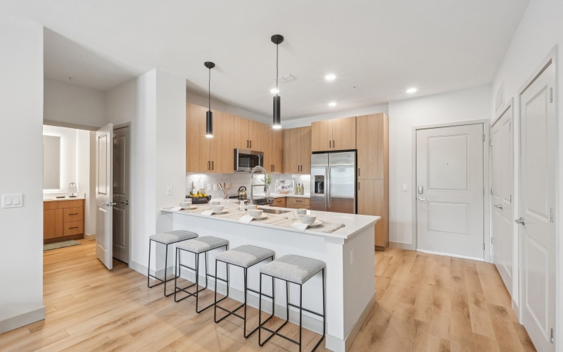 a kitchen with a white counter top and bar stools